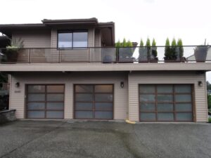 Three modern garage doors with frosted glass panels, expertly installed by Rainier Garage Door in Bellevue, WA.