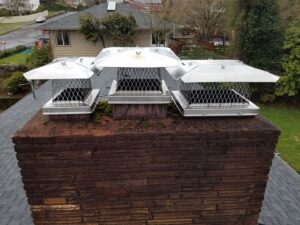 Three new metal chimney caps professionally installed on a brick chimney by Matchbox Chimney Sweeps in Vancouver, WA.