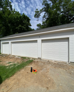 Three newly installed white garage doors on a multi-bay garage by J&C Bravo LLC in Cordova, TN.