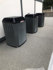 Three outdoor AC condenser units installed side-by-side by 20th Century Heating and Air in Anaheim, CA.