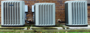 Three outdoor air conditioning units installed against a brick wall by M.W. Kryzak and Sons in Charleston, WV