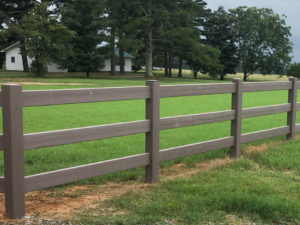 A newly installed three-rail composite fence in a green field by Browning & Sons Fencing, Home Renovations, and More in Suwanee, GA.