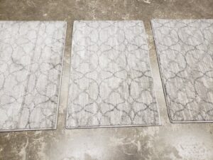 Three small rectangular patterned rugs with bound edges, showcasing custom carpet work by Carpet Binding By Scott in Oklahoma City, OK