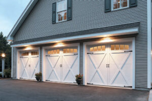 Three elegant white carriage-style garage doors with decorative hardware installed by Overhead Door Company of Evansville in Evansville, IN.
