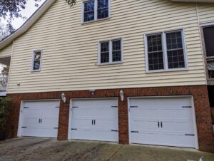 A house featuring three white garage doors installed by Precision Garage Door of Charleston in Charleston, SC.