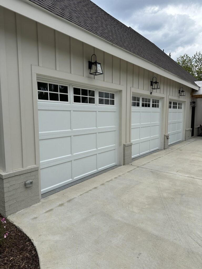Three modern white garage doors installed on a contemporary home by Platinum Garage Door Services in Helena, AL