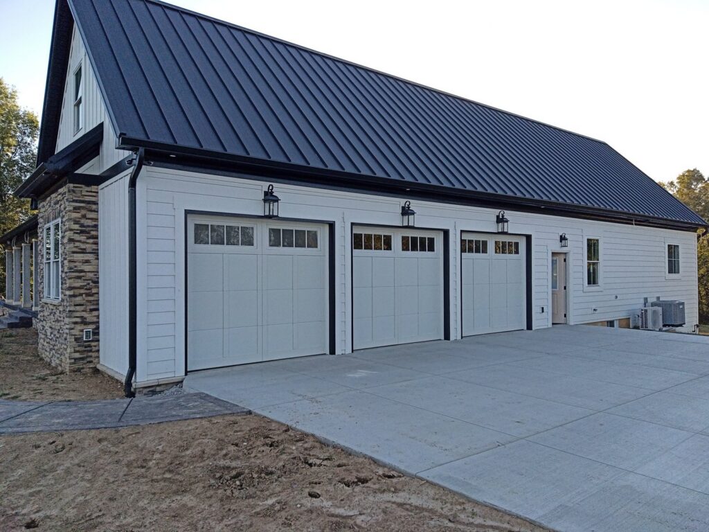 Three white residential garage doors installed on a modern home by Honest Overhead Garage Doors in Elizabethtown, KY.