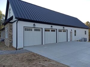 Three white residential garage doors installed on a modern home by Honest Overhead Garage Doors in Elizabethtown, KY.