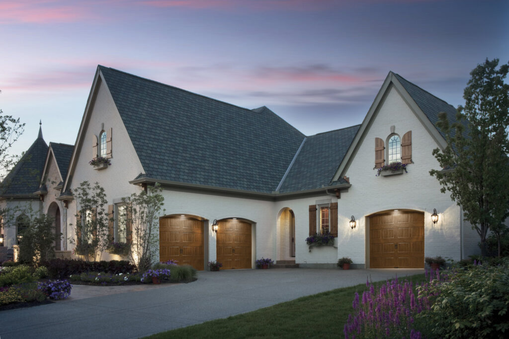Three wood-grain garage doors installed on a large residential home by Babcock Garage Doors in Vancouver, WA