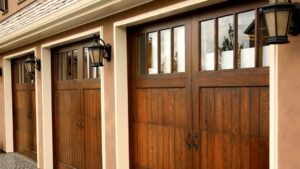 Three elegant wooden-style garage doors with decorative windows and hardware, installed by Above The Rest Garage Door in Colorado Springs, CO.