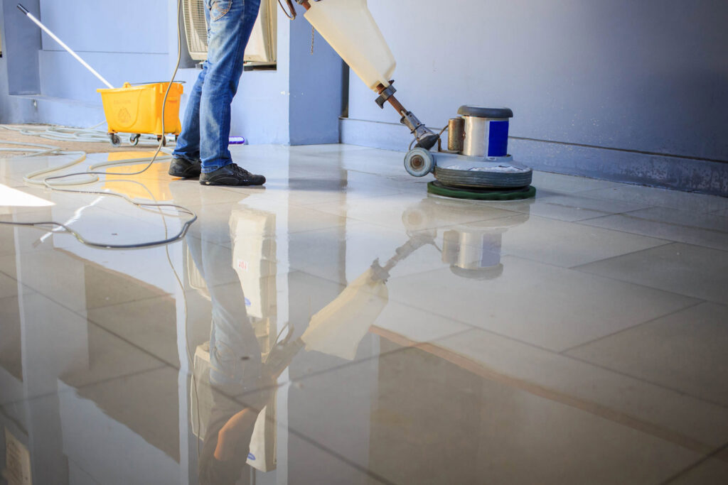 A professional cleaning a tiled floor with a floor buffer, a service by Nashville Carpet Cleaning in Madison, TN.
