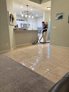 A technician cleaning a tile floor with a rotary scrubbing machine, offered by Carpet Care in Reisterstown, MD.