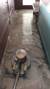 A professional floor scrubber cleaning tile and grout, showing suds, by Certified Carpet Cleaning & Restoration in Skiatook, OK.