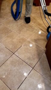 A professional cleaning technician using a rotary machine to clean tile and grout for Carpet Care in Reisterstown, MD.