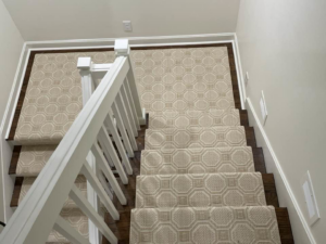 A top-down view of a beige patterned carpet runner installed on stairs and landing by Jimmy's Flooring in Louisville, KY