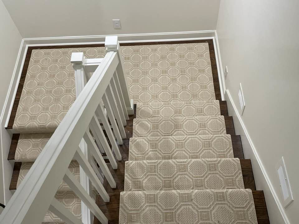 A top-down view of a beige patterned carpet runner installed on stairs and landing by Jimmy's Flooring in Louisville, KY