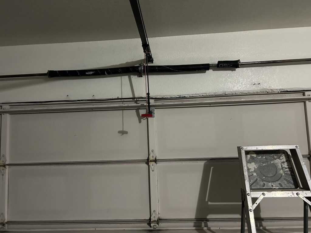 A close-up view of a garage door torsion spring system, ready for replacement by SS Garage Door Repair in Denver, CO.