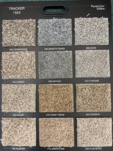 A display board showcasing various "Tracker" carpet samples from PureColor Solutions, available at Rojas Carpet and Flooring in Denver, CO.
