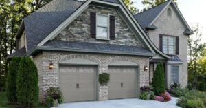 Two traditional garage doors on a brick and stone home installed by American Overhead Door in Madison, AL