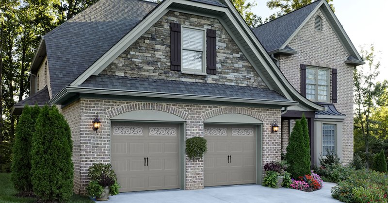 Two traditional garage doors on a brick and stone home installed by American Overhead Door in Madison, AL