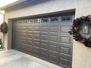 A traditional panel garage door with decorative windows installed by Blue Fox Garage Doors in Gilbert, AZ.