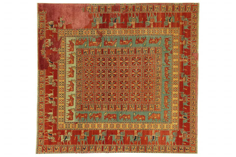 A traditional red and green patterned carpet, part of the collection at Woven Legends in Philadelphia, PA.