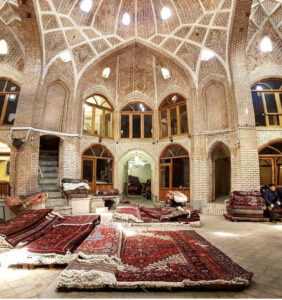 A traditional market setting with numerous ornate rugs laid out on the floor, representing the products of Accents Galleria in Kansas City, MO
