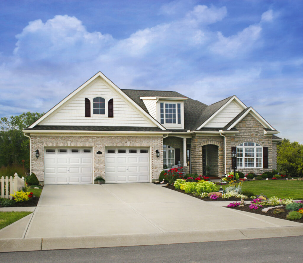 Two traditional white panel garage doors on a classic residential home, showcasing work by Babcock Garage Doors in Vancouver, WA
