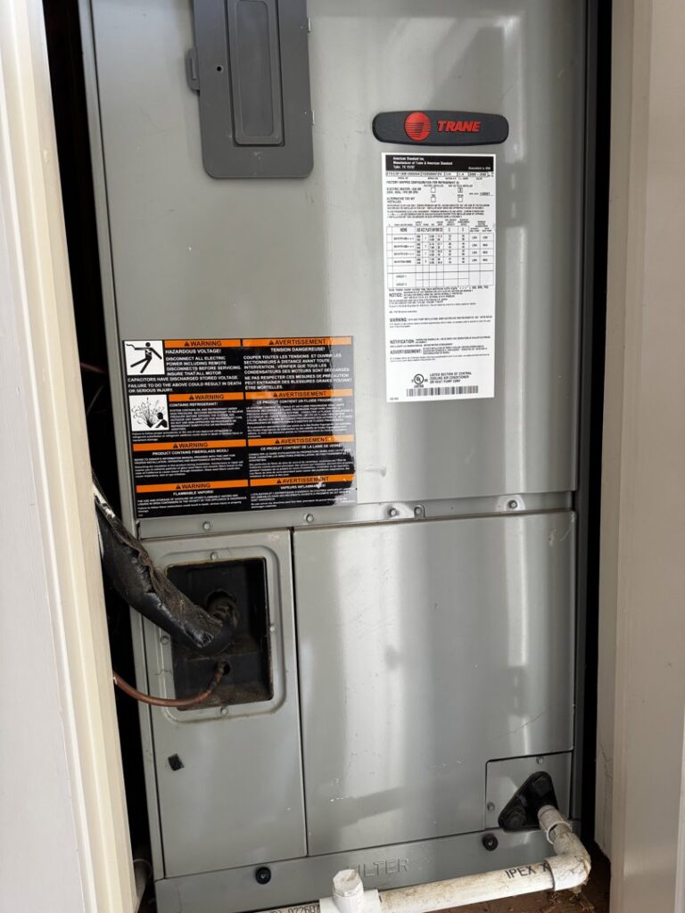 A Trane air handler unit installed in a utility closet, serviced by OnPoint Heating and Air in Commerce City, CO.