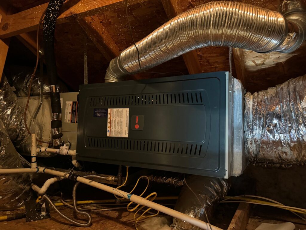 A Trane indoor air handler and furnace unit with ductwork installed in an attic by Fort Worth Air Conditioning Co. Inc. in Fort Worth, TX.