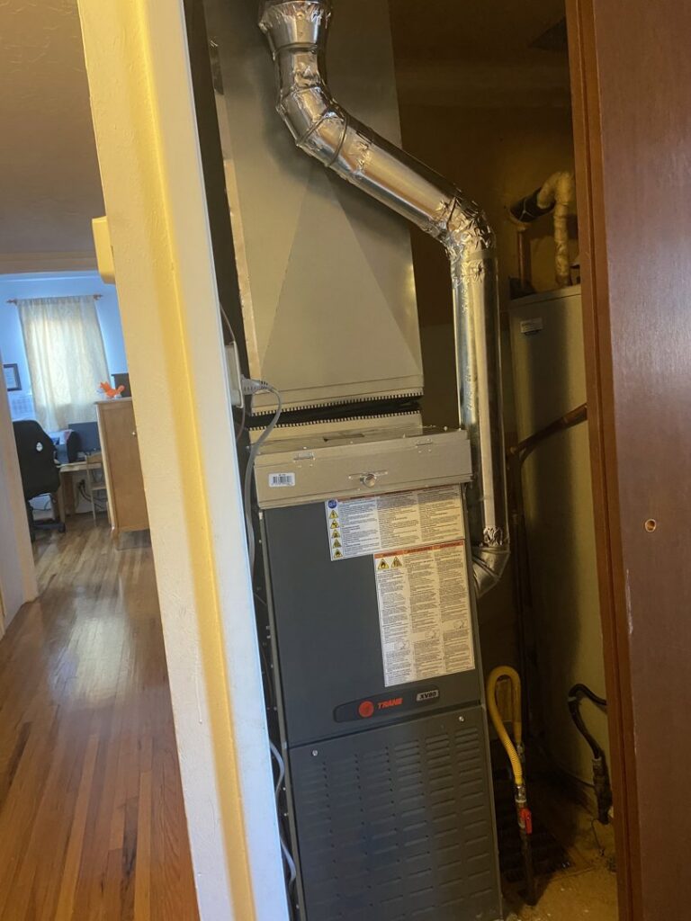 A Trane furnace or air handler unit with ductwork and a water heater installed by Santa Fe Heating & Cooling LLC in Santa Fe, NM.