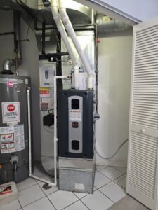 A Trane furnace and air handler unit installed next to a water heater by Cosmic HVAC in Chicago, IL.