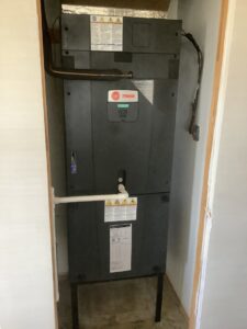 A Trane indoor air handler unit installed in a utility closet, expertly serviced by Valle Del Sol Home Services, LLC in Scottsdale, AZ.