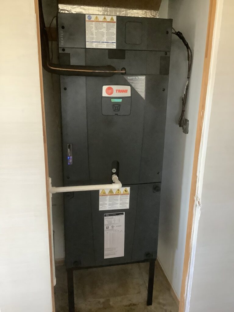 A Trane indoor air handler unit installed in a utility closet, expertly serviced by Valle Del Sol Home Services, LLC in Scottsdale, AZ.