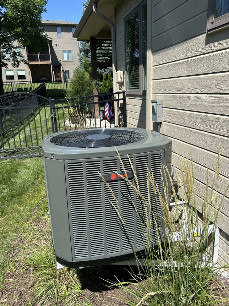 A Trane outdoor air conditioning unit at a residential property serviced by Sandys Heating & Air in Papillion, NE.