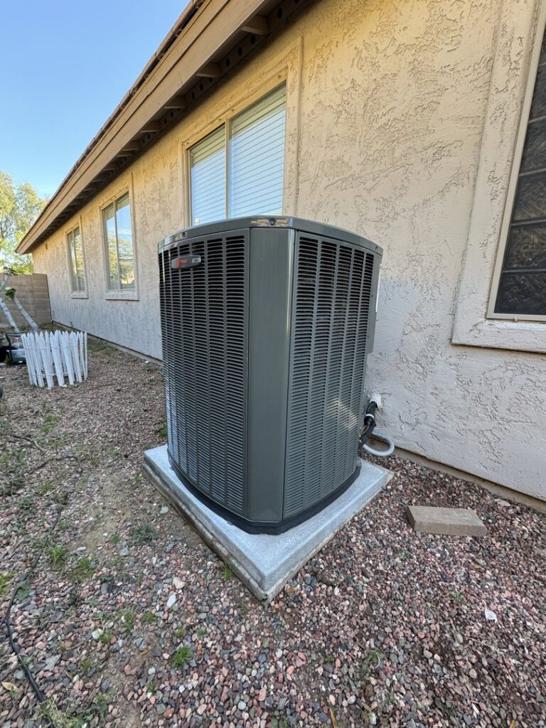 A Trane XR outdoor AC unit installed next to a residential building by Mi Amigo HVAC in Surprise, AZ