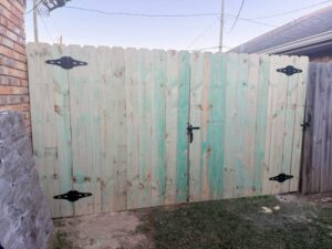 A newly installed treated wood privacy fence featuring a double gate by 985 Fence, LLC in Schriever, LA.
