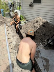 Electricians digging a trench for underground electrical conduit installation by Dynamic Electric in Cape Coral, FL.