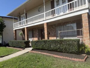 A residential front yard featuring neatly trimmed hedges and freshly mulched garden beds by God's Sight Lawn & Gardens LLC in New Orleans, LA
