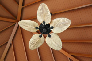A tropical style ceiling fan with palm-leaf blades installed on a wooden ceiling by Chuck's Electrical Services in Ewa Beach, HI.