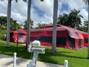 A tropical home covered in a red and black fumigation tent by PNP Pest Solutions LLC in Miami, FL.