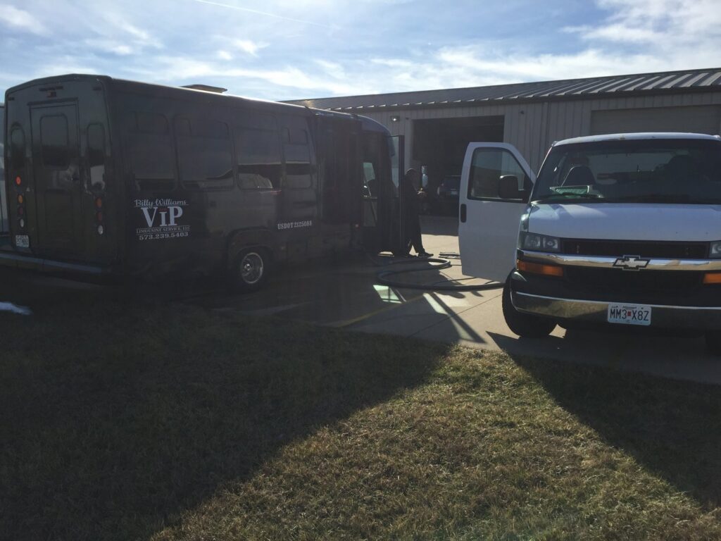 A C&C Carpet Care LLC truck-mounted carpet cleaning system with hoses connected to a building in Columbia, MO.