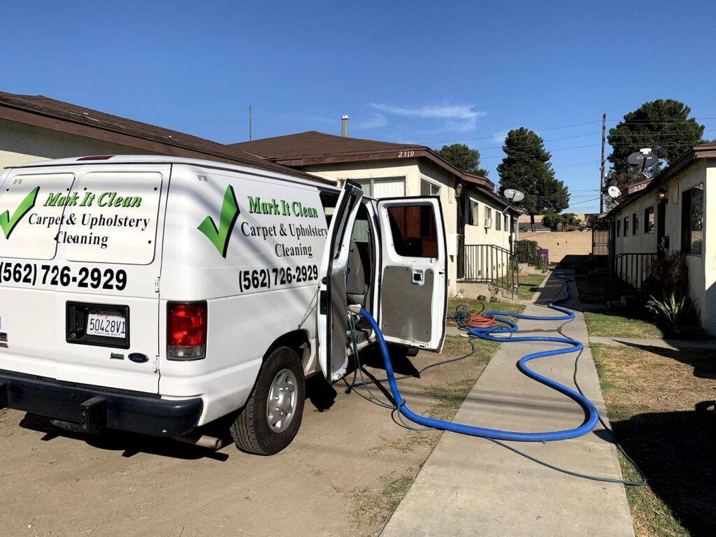 A Mark it Clean Carpet & Upholstery Cleaning van with hoses extended for truck-mounted cleaning service in Long Beach, CA.