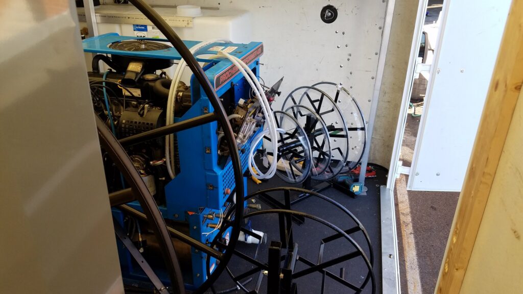 Interior of a work van showing a truck-mounted carpet cleaning unit and hose reels for My Carpet Cleaning & Restoration Services in Silver Spring, MD.