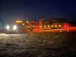 A work truck transporting fencing materials and equipment on a trailer at night for Cool Hand Fencing and Wyo War Wagons in Laramie, WY.