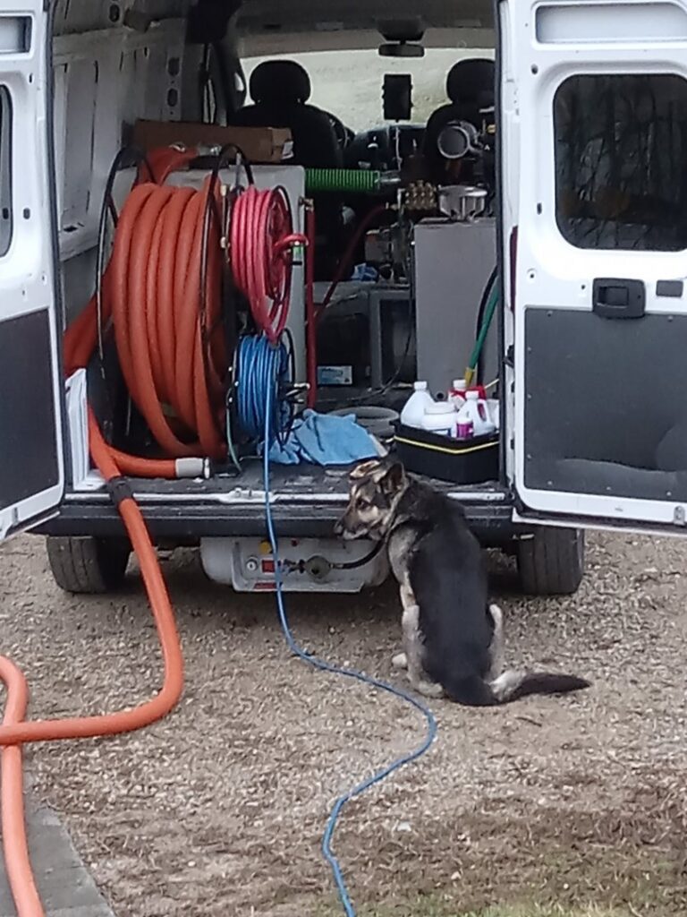 Truckmount carpet cleaning equipment visible inside an Alpha Clean service van in Fort Wayne, IN.