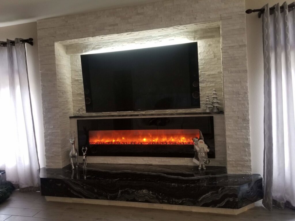 A mounted TV and electric fireplace integrated into a stone wall, installed by Neptune Electric LLC in Las Vegas, NV