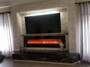 A mounted TV and electric fireplace integrated into a stone wall, installed by Neptune Electric LLC in Las Vegas, NV