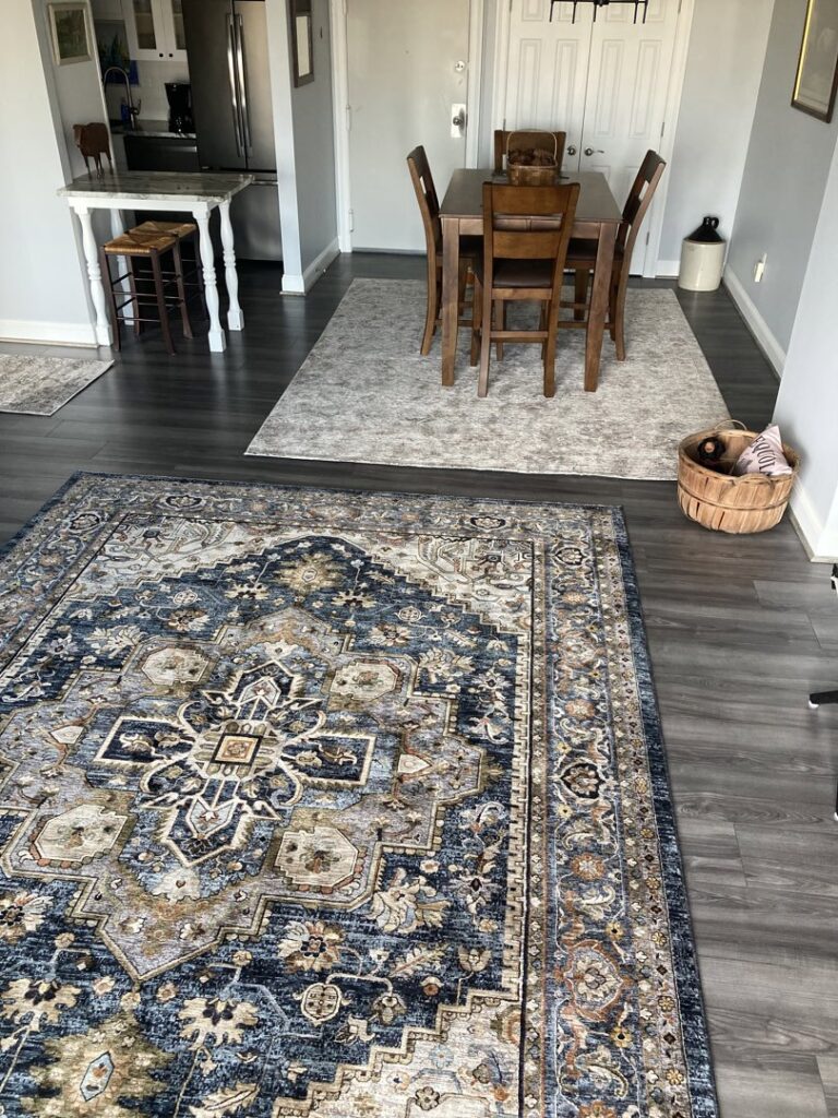 Two elegant area rugs defining living and dining spaces in a home by Kaoud Rugs in West Hartford, CT.