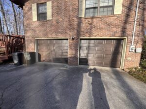 Two beige garage doors installed on a brown-sided building by Skylift Garage Doors - Knoxville, TN